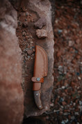 Handcrafted leather knife sheath and knife cover with border tooling and single strap snap closure.
